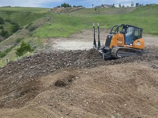 Compact track loader preparing a rocky Montana jobsite